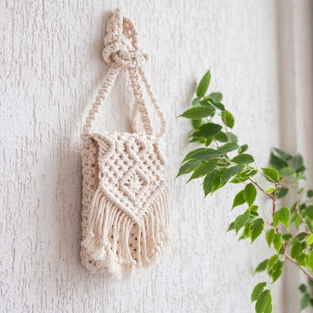 Handmade macrame bag on white background ECO friendly natural macrame cotton bag for woman Hobby knitting handmade macrame Modern summer concept