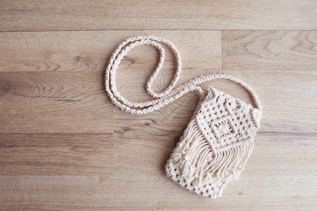 Handmade macrame bag on wooden background ECO friendly natural macrame cotton bag for woman Hobby knitting handmade macrame Modern summer concept