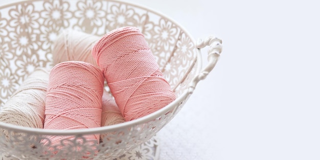 Handmade macrame braiding and cotton threads in basket on white background Cotton macrame cords