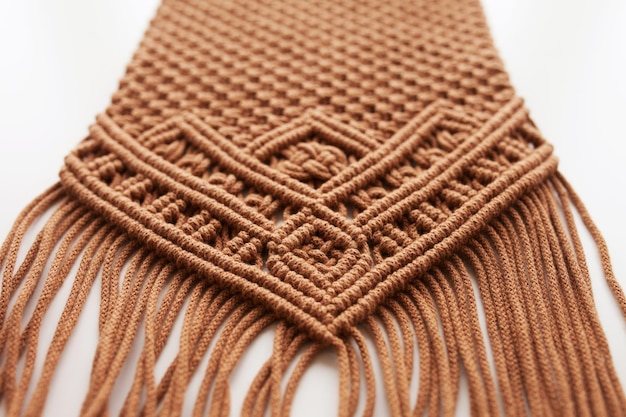 Handmade macrame pattern close up. Macrame braiding and cotton threads on wooden table.  Female hobby.  ECO friendly modern knitting DIY natural decoration concept in the interior. Copy space