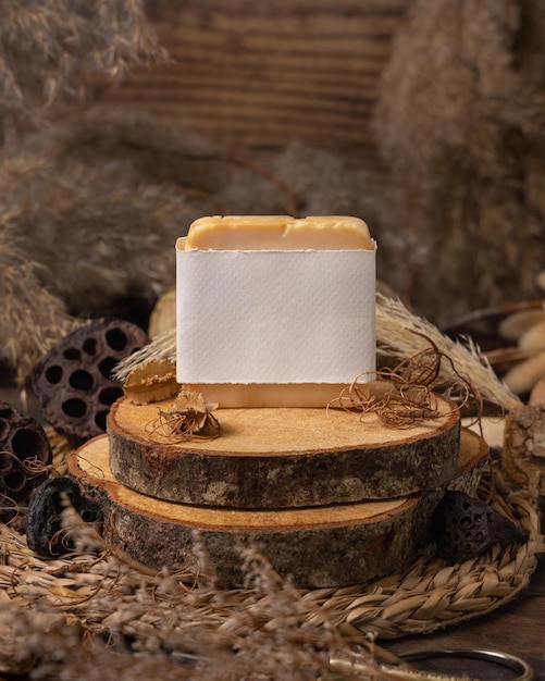 Handmade soap bar with blank label on wood near natural decorations close up Mockup