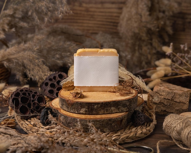 Handmade soap bar with blank label on wood near natural decorations close up Mockup