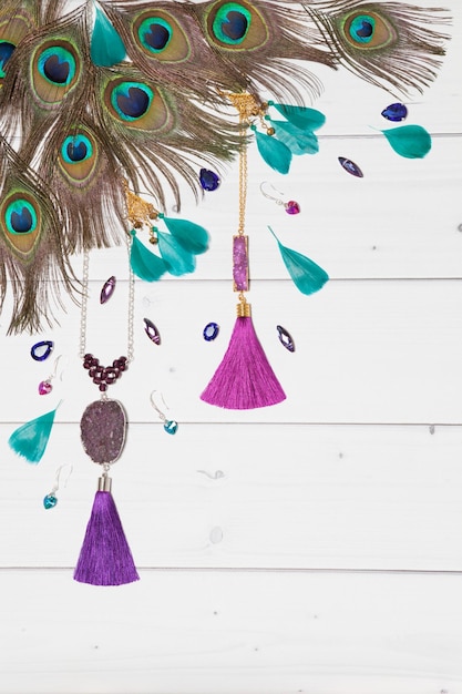 Handmade turquoise and violet bijouterie with gems tassels and peacock feathers in boho style