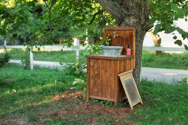 Handmade wooden wash basin with soap in garden for hands cleaning in summer outdoor sink in yard