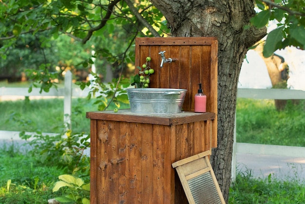 Handmade wooden wash basin with soap in garden for hands cleaning in summer.