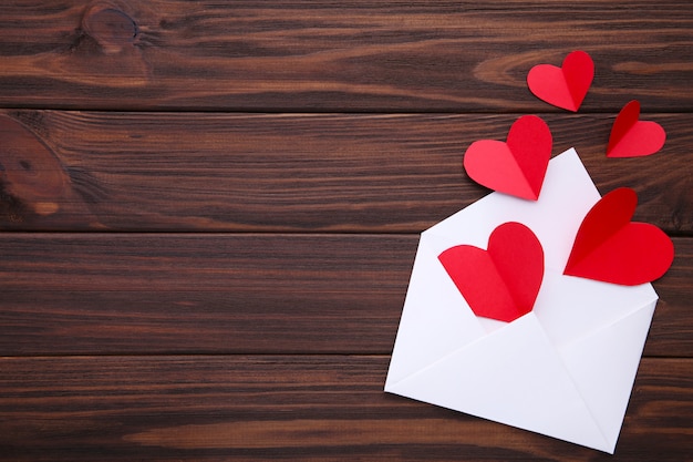 Handmaded red hearts in envelope on white background.