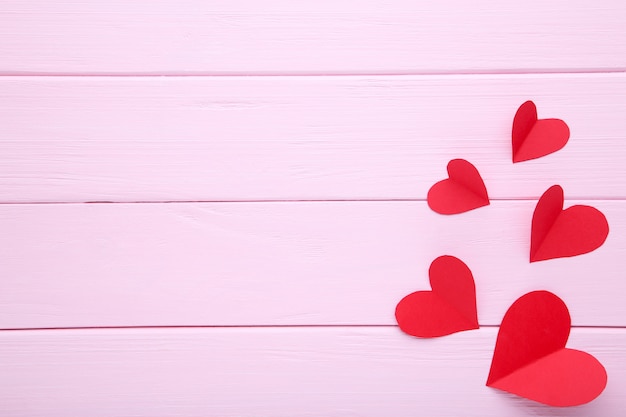 Handmaded red hearts on pink background.