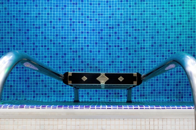 Handrail on pool Swimming pool with stair at the fitness centre A swimming pool water the clear blue to swim water and exercise