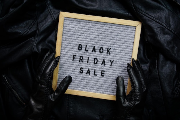 Hands in black gloves hold a frame with the inscription black friday sale