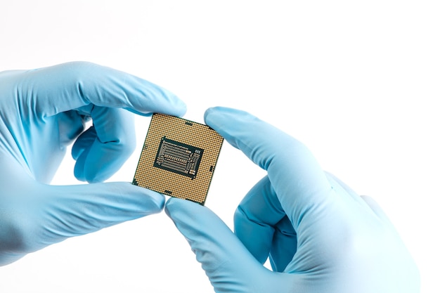 Hands in blue gloves hold micro processor cpu on white background close up