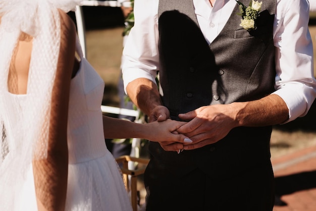 Hands of the bride and groom hold together on the wedding day