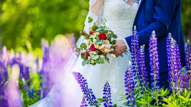 Hands of the bride and groom with rings on a beautiful wedding bouquet