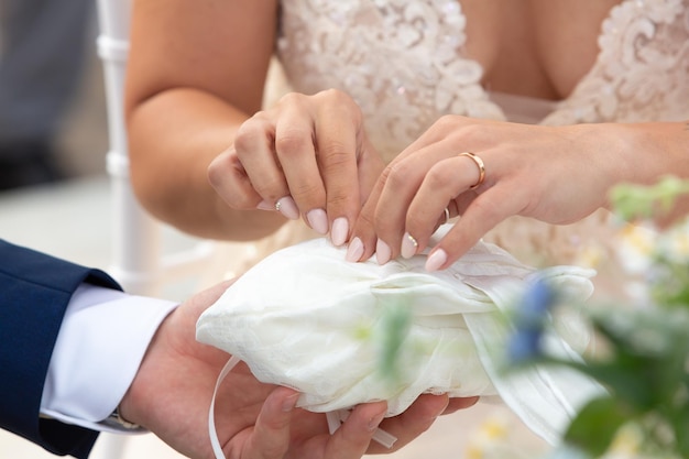 Hands of the bride during the wedding as they take the wedding ring for the exchange of rings