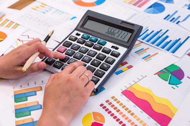 Hands of business analyst calculating graphs and diagrams