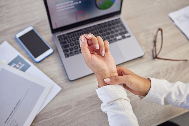 Hands business woman and pain in wrist from typing on laptop orthopedic injury or health risk from above Closeup of worker carpal tunnel and muscle problem from stress fibromyalgia and arthritis