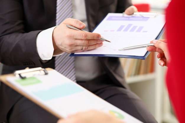 Hands of businessman discussing financial report with woman colleague