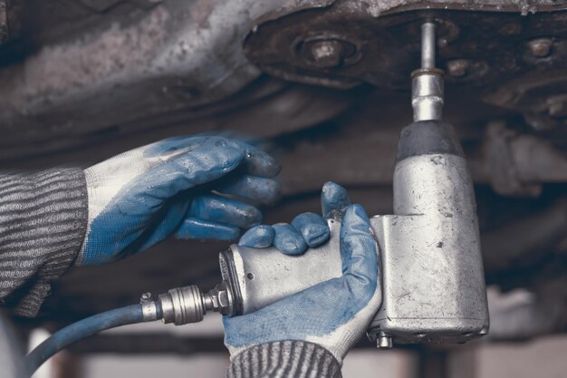 Hands of car mechanic in auto repair service.