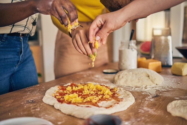 Hands cheese and pizza for cooking together and ready for fast food restaurant or helping with skill in Naples Chef woman dough and tomato sauce for cuisine culture and preparation with process