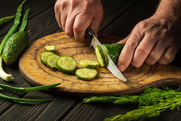 Hands of a chef with a knife while cooking in a restaurant kitchen