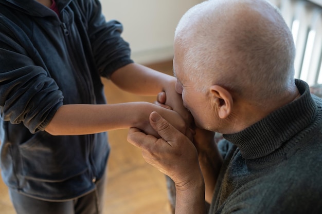 The hands of the child embracing a hand of the old man