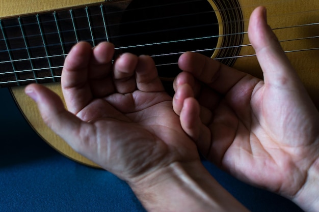 Photo hands of a classical guitarist on top of the guitar