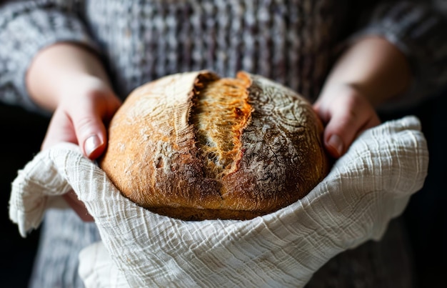 Hands Cradling a Freshly Baked Loaf of Bread in a Cozy Kitchen Setting