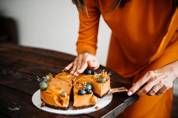 Hands cut a festive eco cake with fruits and berries