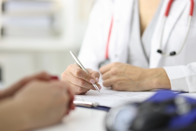 Hands of doctor and patient on work table in medical office medical examination concept