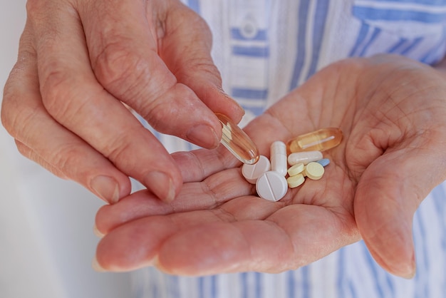 In the hands of an elderly woman there are many different pills for diseases