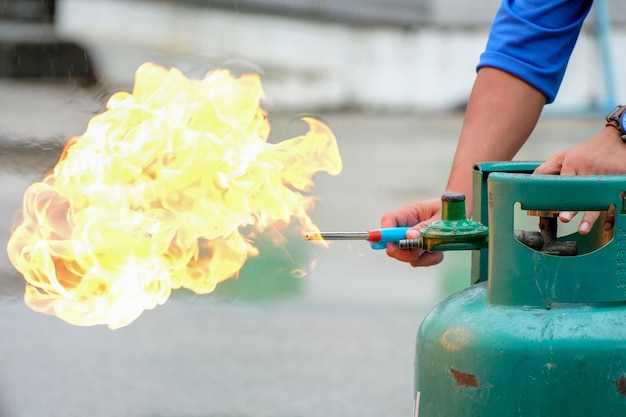 Hands of experts light gas cylinders for fire prevention drills in the workplace