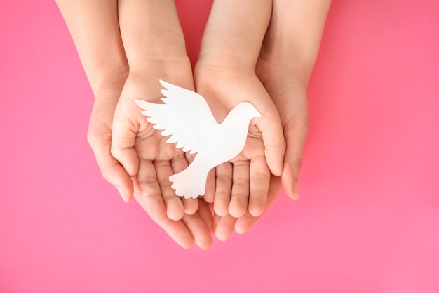 Hands of family with paper dove