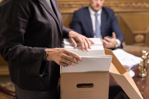 Hands of female lawyer looking for juridical papers in box