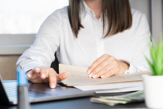 Hands of a financial worker in a white shirt working with documents close-up.