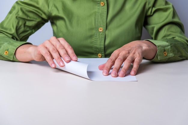 Hands folding a sheet of paper