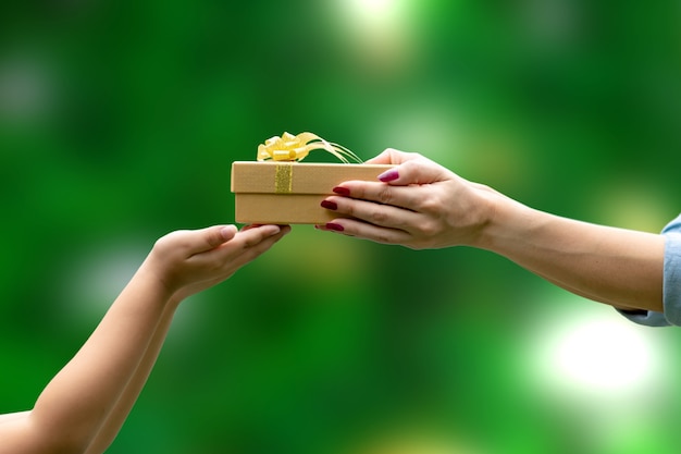 Hands Give a gift congratulation Thank You green background