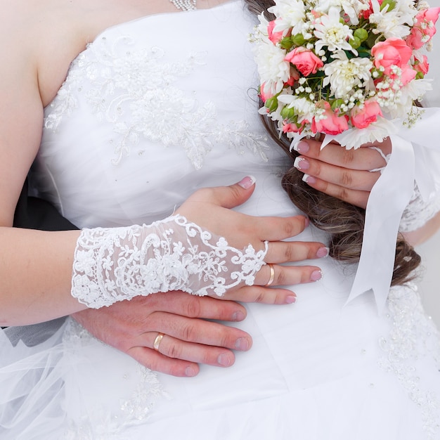 Hands of the groom and the bride with wedding rings