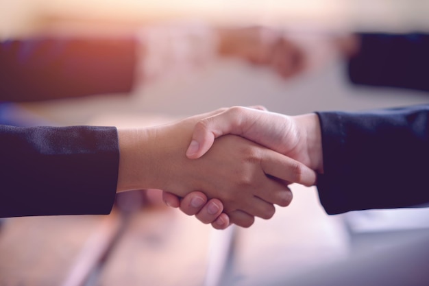 The hands of a group of businessmen shake hands to reach an agreement in a company meeting