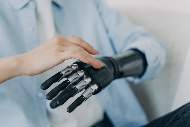 Hands of handicapped girl setting up her bionic arm and pressing buttons Robotic bionic prosthesis