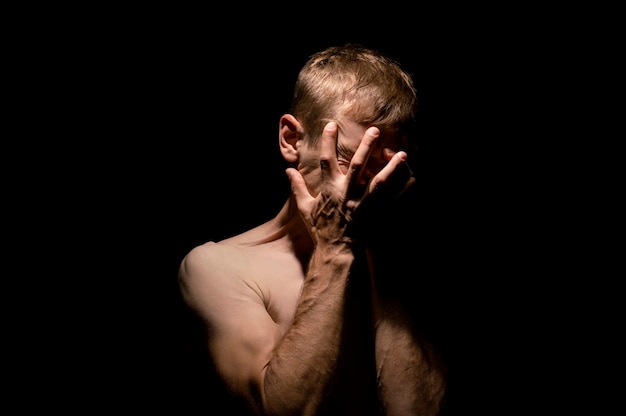 Hands on head, black and white dramatic photo of a man