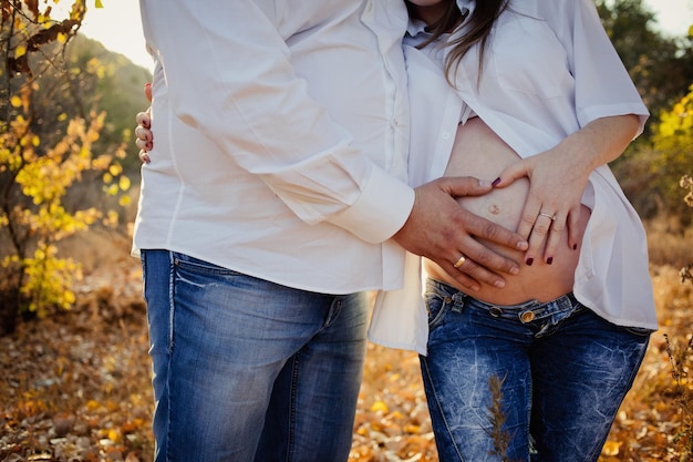 Hands heart shape on the belly pregnant woman Belly close up shot