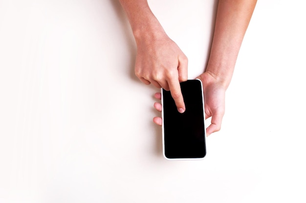 Hands hold a phone on a white background isolated. View from above