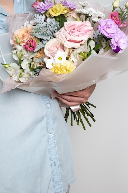 Hands holding bouquet of beautiful flowers Toned picture Without a face