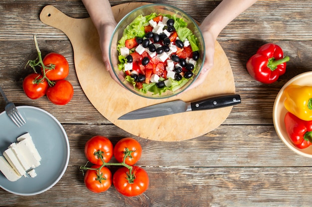 Hands holding a bowl with salad