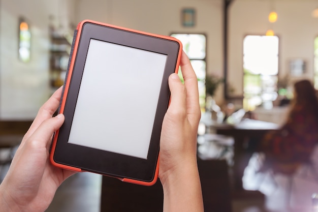 Photo hands holding computer tablet with coffee shop background