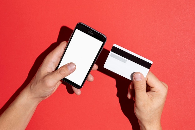 Hands holding a credit card and a phone mock up