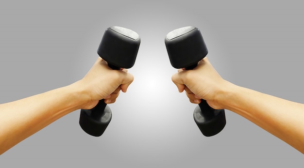 Hands holding dumbbells in sport club or gym and fitness room