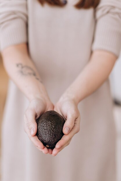 Hands holding fresh avocado Closeup Hand Holding Hass Avocado