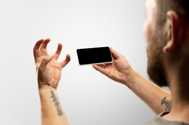 Hands holding gadget on white background