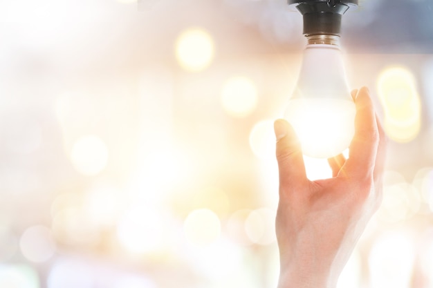 Hands holding glowing light bulbs