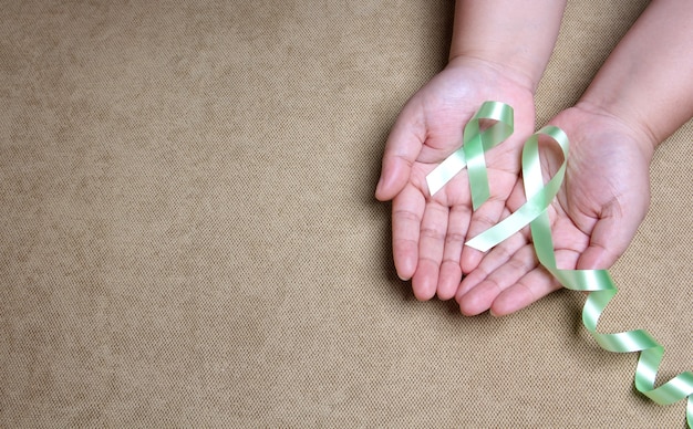 hands holding Green ribbon With copy space.